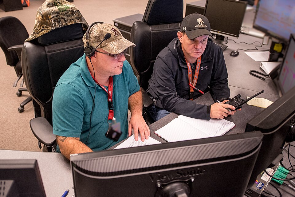 Operators reviewing control screens and escalation notes